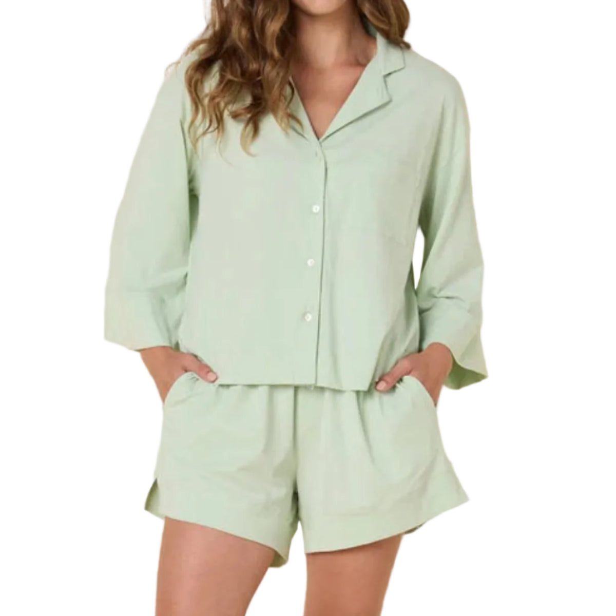 Woman wearing a light green pajama set against a white background