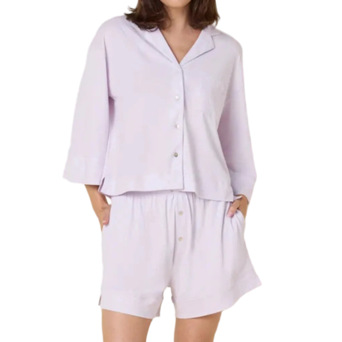Woman wearing a lavender purple pajama set against a white background
