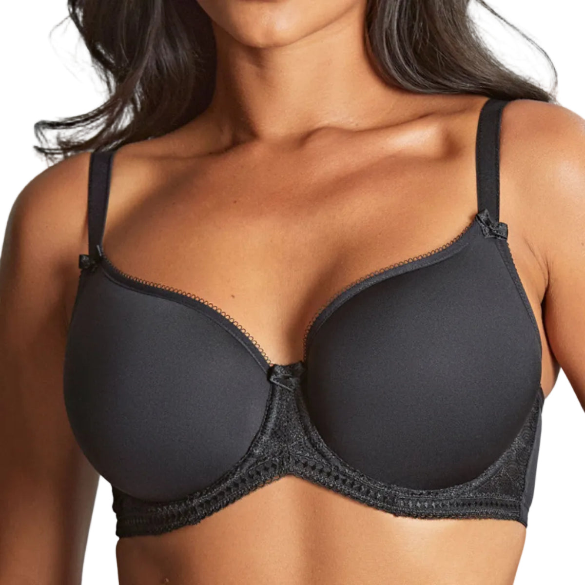 Woman wearing a black bra against a white background