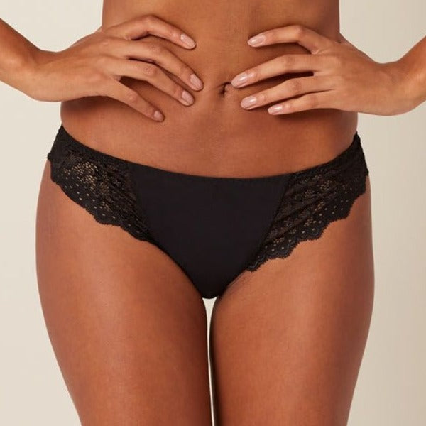 Simone_Perele_12A710_Caresse_Tanga_Black  •	Mid-rise tanga with Brazilian-style back •	Front panel made of ultra-light microfiber •	Ultra-soft stretch lace with scalloped trim at the hips and back •	Lace is woven with a blend of matte and sheen threads for a chic finish •	Cotton gusset on panty