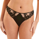 Black lace and mesh panties worn by a model, shown from the waist to upper thighs against a light beige studio background.