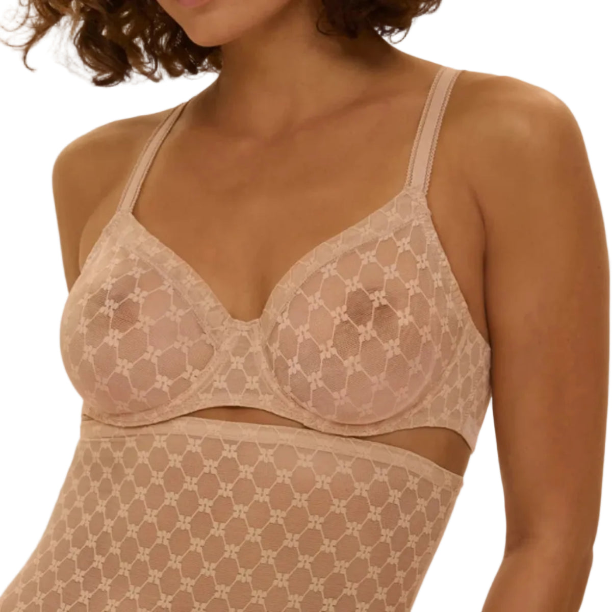 Woman wearing a beige lace lingerie set against a beige background