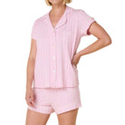 Woman wearing a pink pajama set on a white background