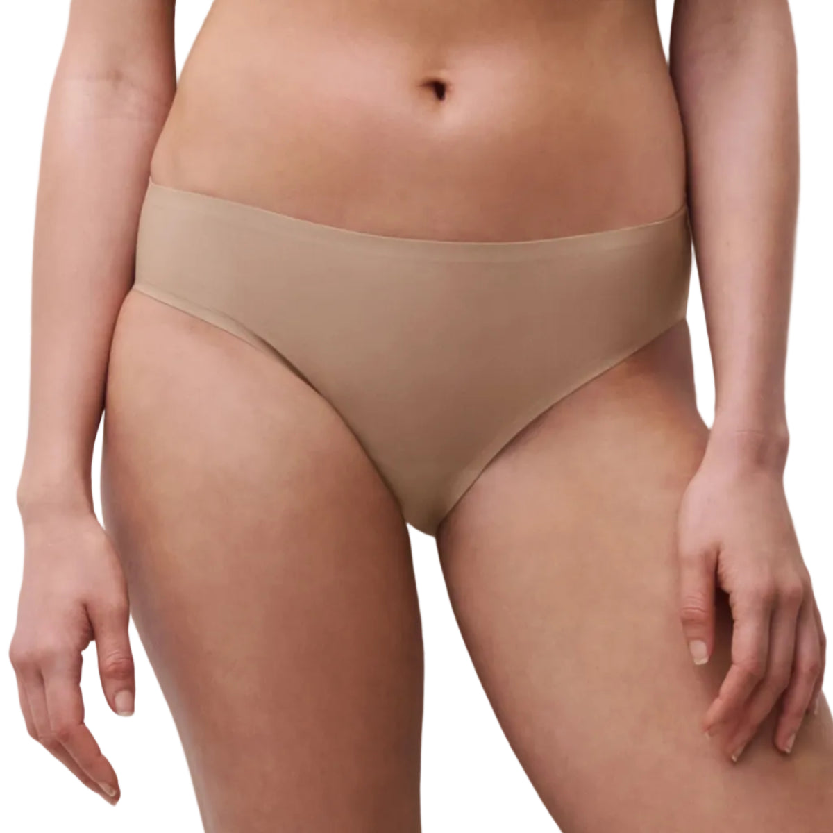 A close-up of a model wearing a pair of high-waisted, low-rise briefs in a solid beige color, shown from the waist to the upper thighs against a neutral light gray background.