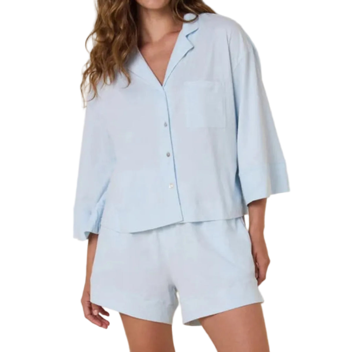 Woman wearing a light blue pajama set against a beige background