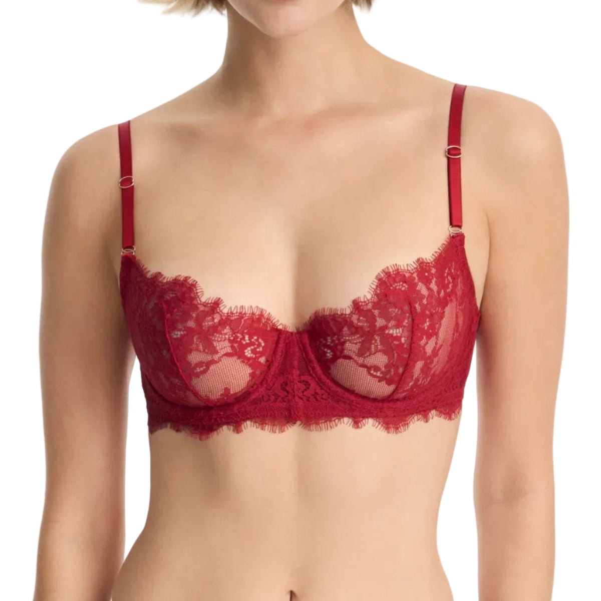 Woman wearing a red lace bra against a white background