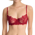 Woman wearing a red lace bra against a white background