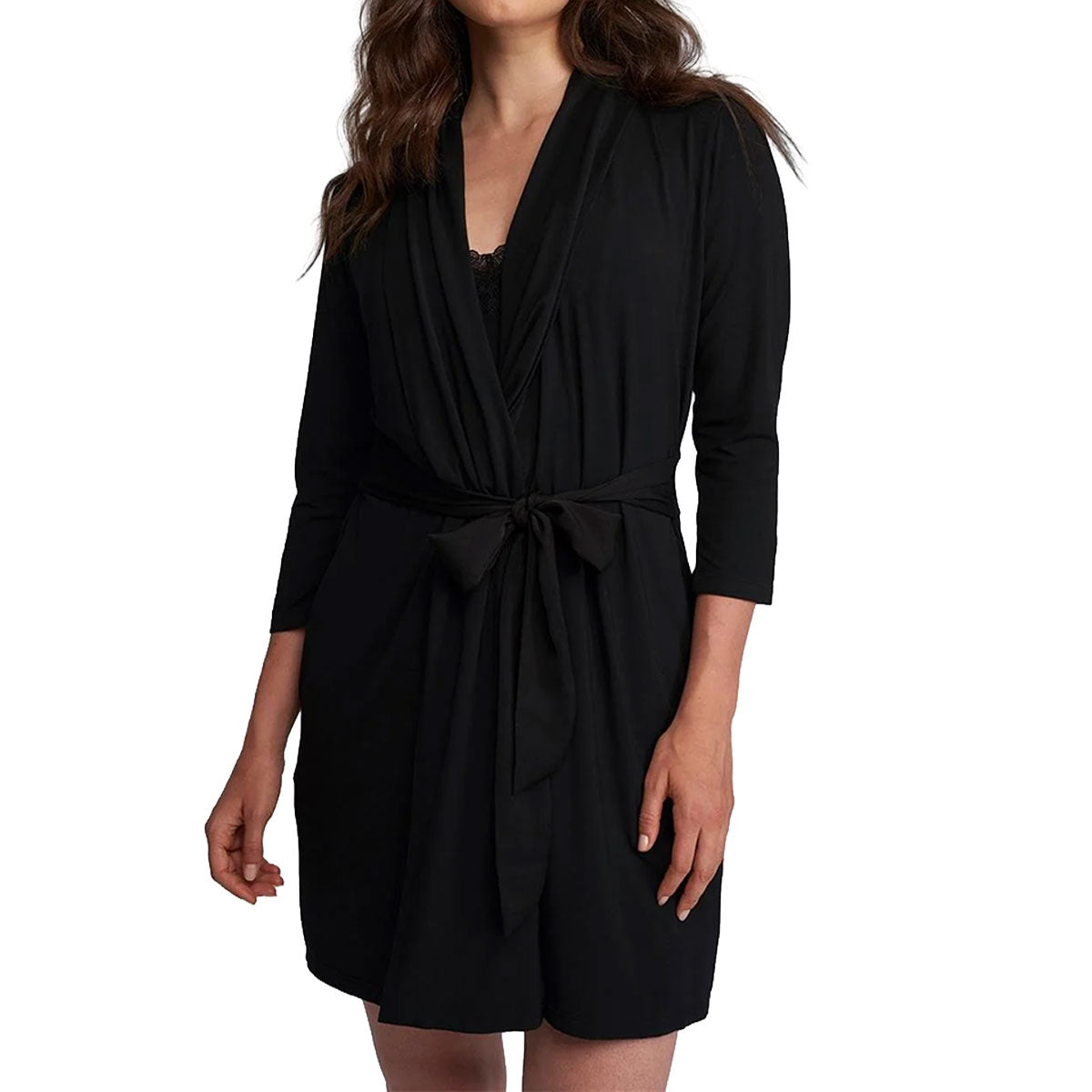 A woman wearing a black wrap-style romper or short dress with three-quarter sleeves and a self-tie belt, shown against a plain white studio background.