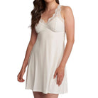 A woman wearing a short, sleeveless nightgown in a warm off-white or cream color. The nightgown features a lace-trimmed scoop neckline and a flared skirt, shown against a plain white background.