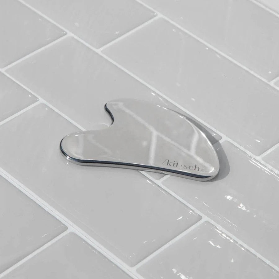 Metallic kitchen tool on a tiled surface with 'kit-sch' branding.