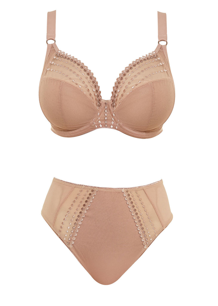 Sheer plunge underwire bra in café au lait beige is a lingerie drawer essential. Embroidered bead detail makes this basic shine! The low center front gives this plunge-style bra cleavage enhancement without added padding. The three-section cup with side panel gives forward shape, separation and excellent lift. Versatile moveable J-hook fastening allows the back to be converted easily and quickly to a racer-back bra style.  Bra and pantie set  on white background.